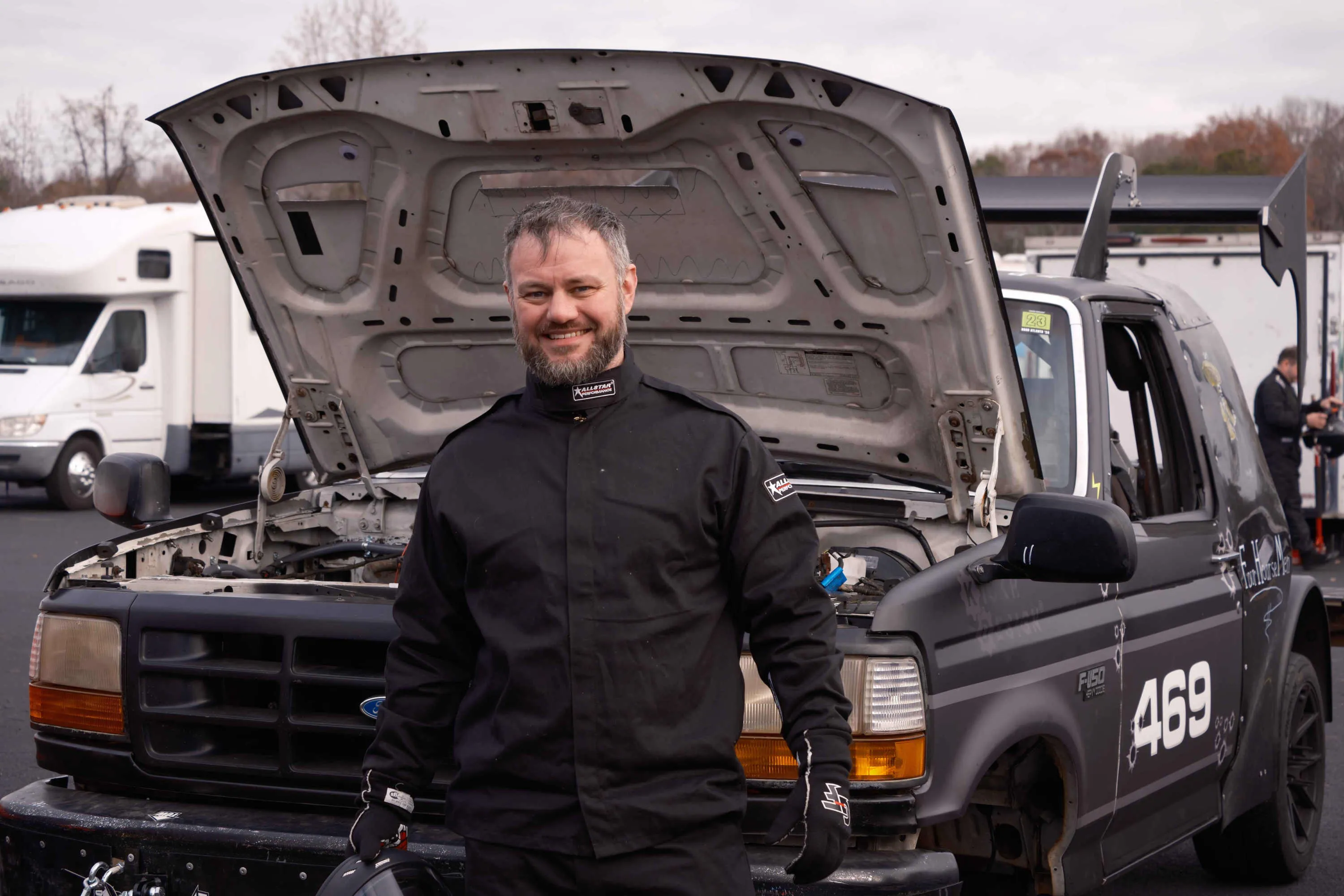 An engineer standing in front of a race car.